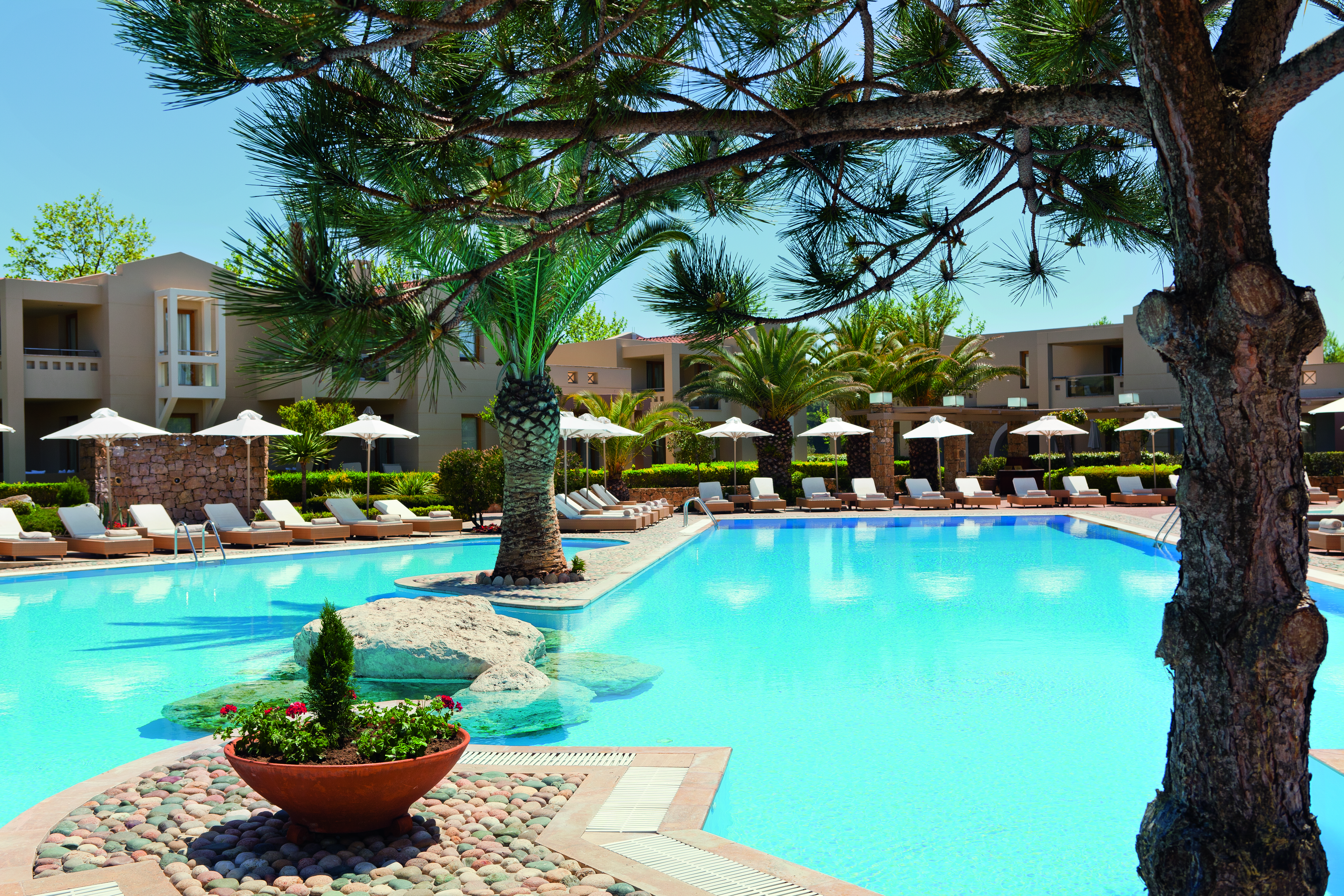 Porto Sani Greece outdoor swimming pool with sun loungers and umbrellas