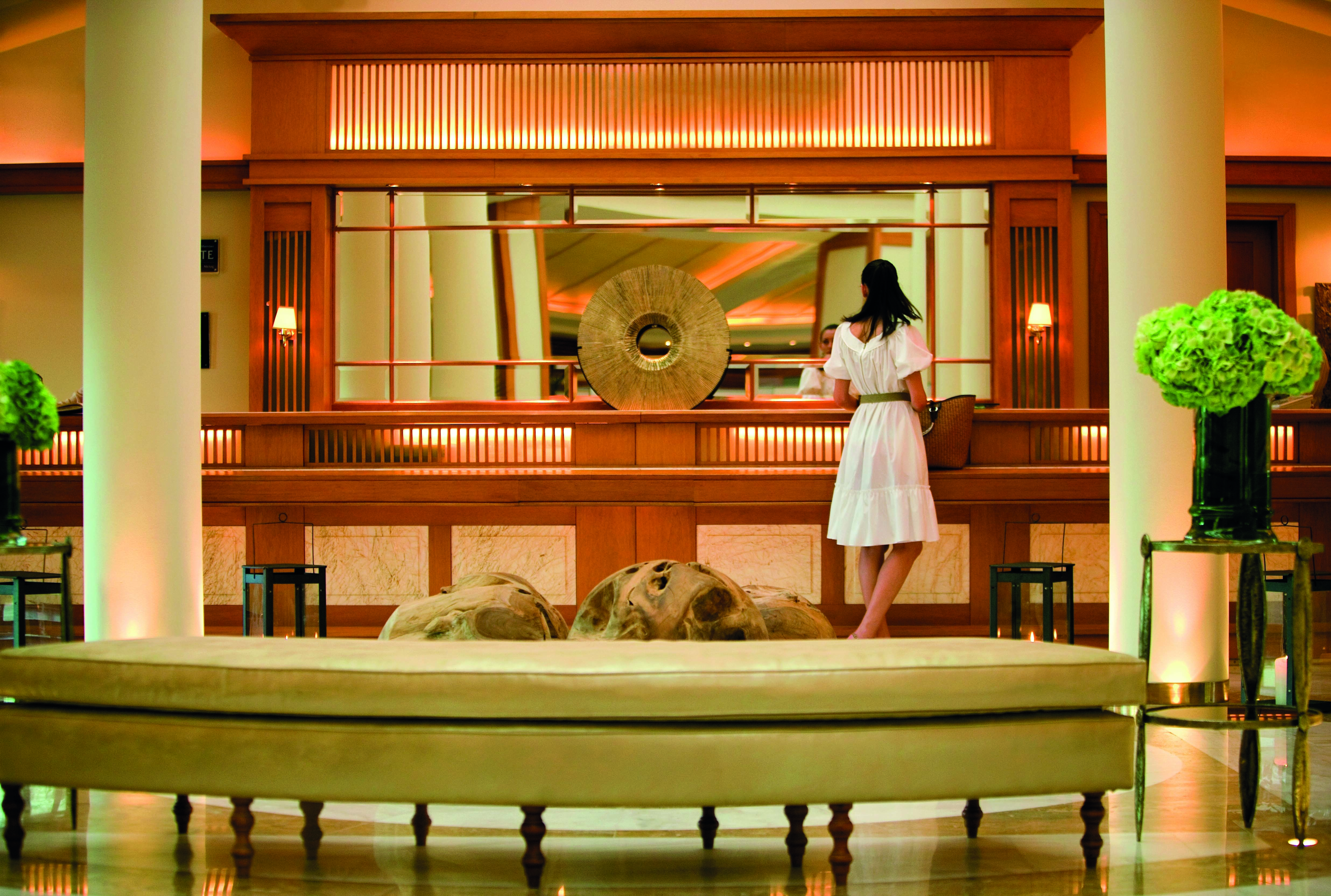 Porto Sani Greece reception woman standing at a wooden reception area and sofas