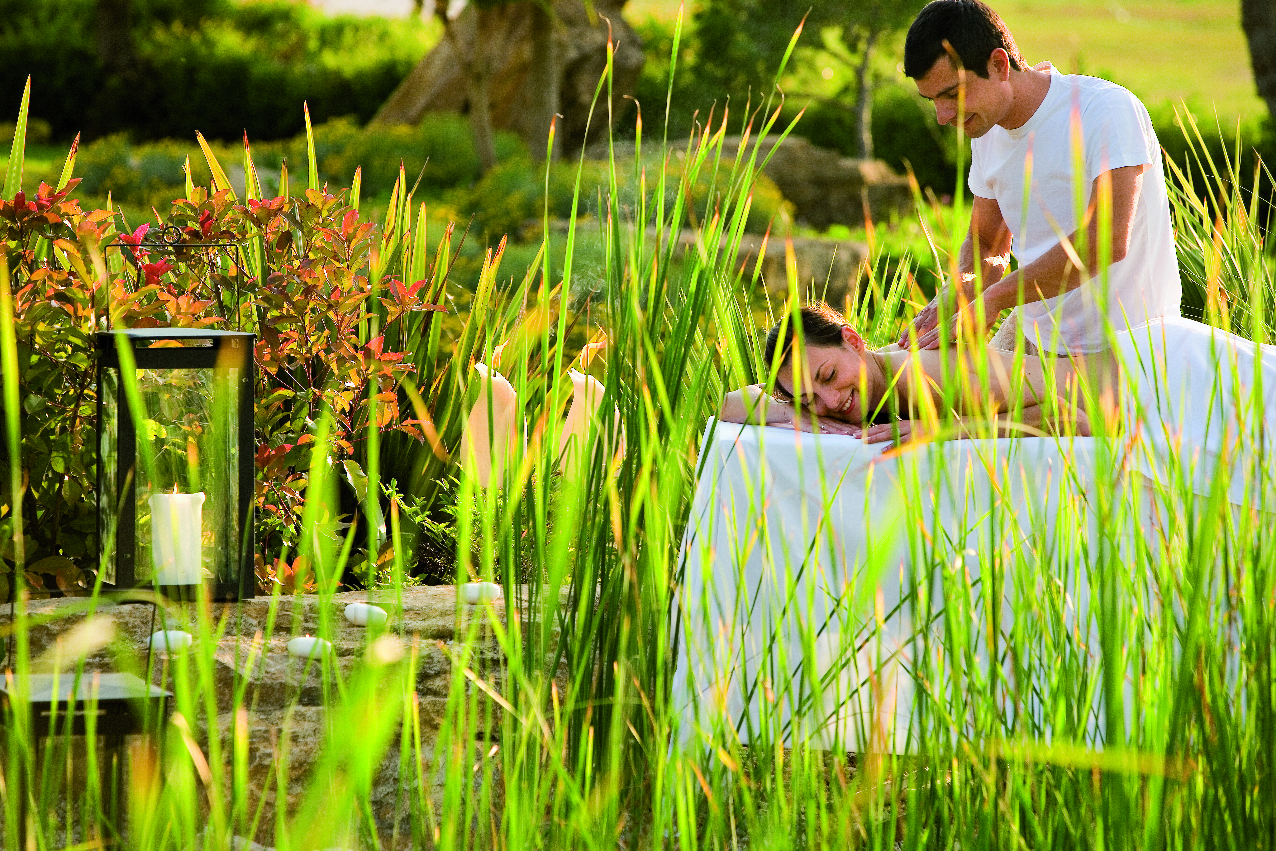 Porto Sani Greece spa man giving a woman a massage in a garden area 