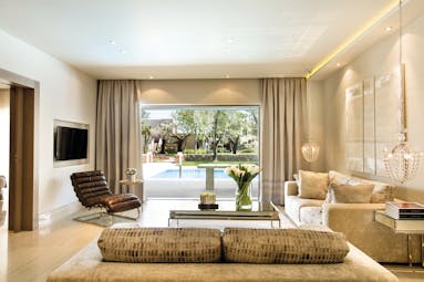 Sani Asterias Greece family suite lounge area with sofas and view of private swimming pool