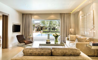 Sani Asterias Greece family suite lounge area with sofas and view of private swimming pool