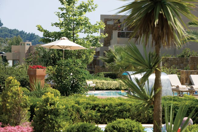 Sani Asterias Greece gardens next to outdoor pool with lounger