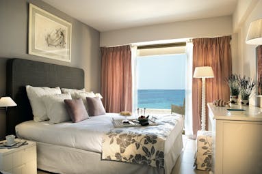 View of a Sani Beach family bedroom including a double bed and a large window a sea view