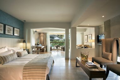 Junior Suite room at the Sani Beach with a large double bed and paintings on the walls