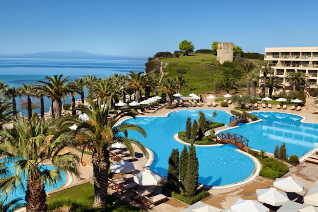 Overview of the main pool at the Sani Beach with palm trees surrounding the blue pool