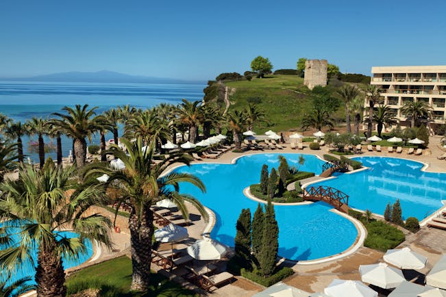 Overview of the main pool at the Sani Beach with palm trees surrounding the blue pool