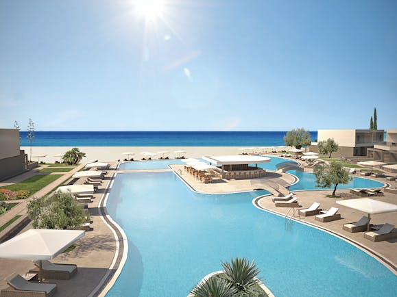 Overview of the pool at Sani Dunes with sunbeds and umbrellas surrounding the pool and leading onto the beach 
