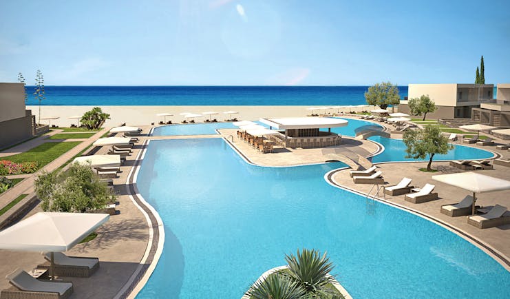 Overview of the pool at Sani Dunes with sunbeds and umbrellas surrounding the pool and leading onto the beach 