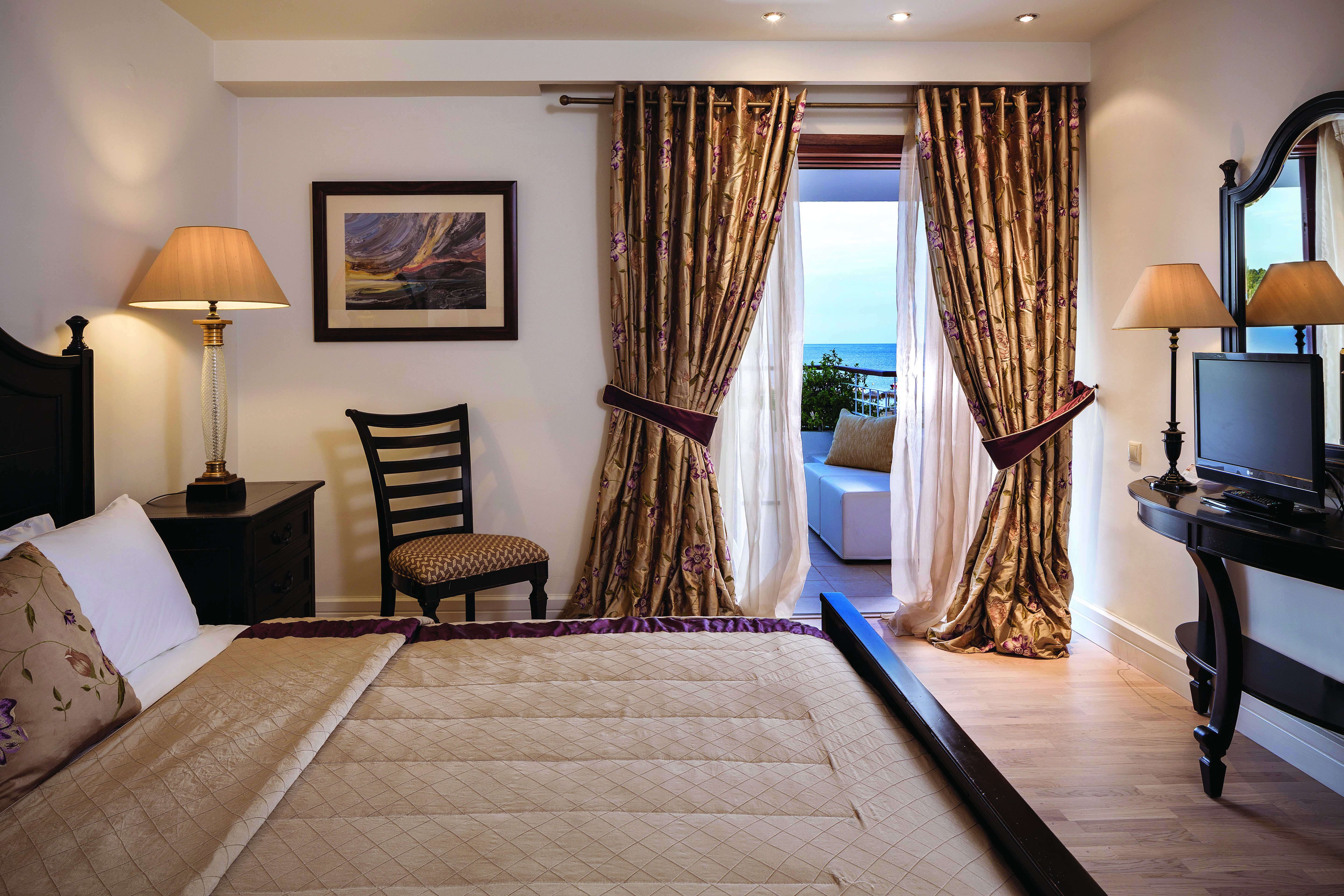 Bedroom at the Skiathos Princess Hotel in greece with large double bed, beige colour scheme and balcony with sea view