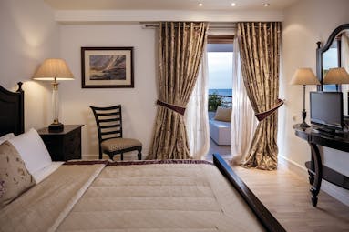 Bedroom at the Skiathos Princess Hotel in greece with large double bed, beige colour scheme and balcony with sea view
