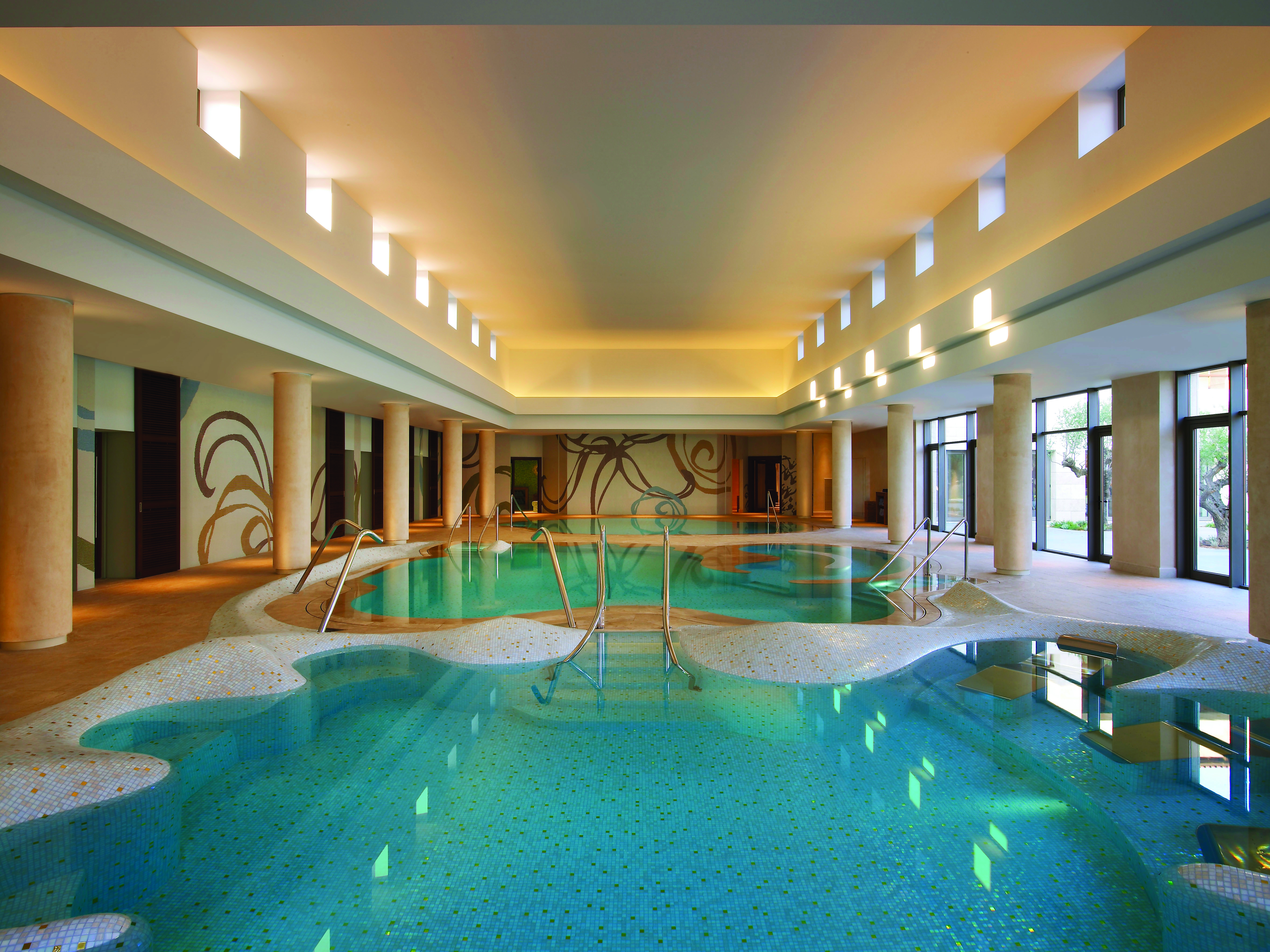 The Romanos Greece indoor pool with large windows 
