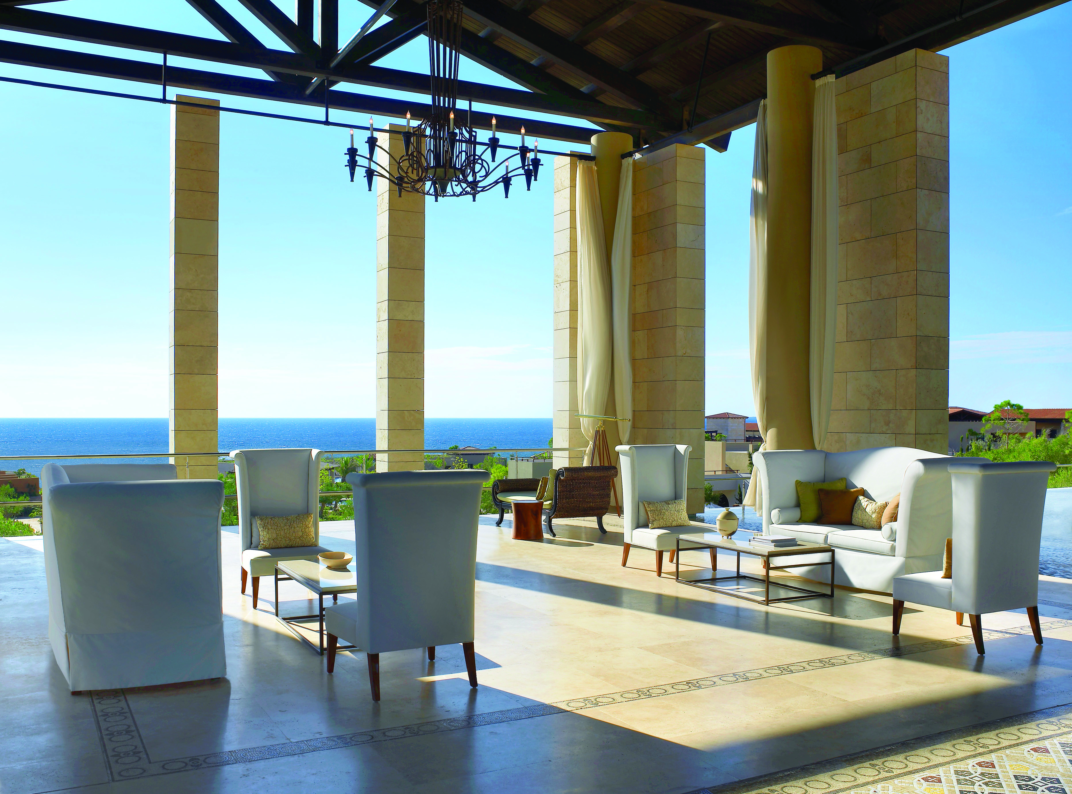 The Romanos Greece outdoor lobby with chairs and sofas