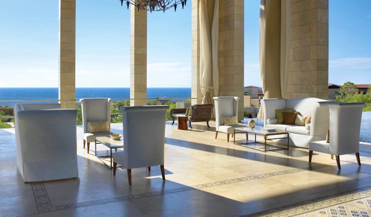 The Romanos Greece outdoor lobby with chairs and sofas