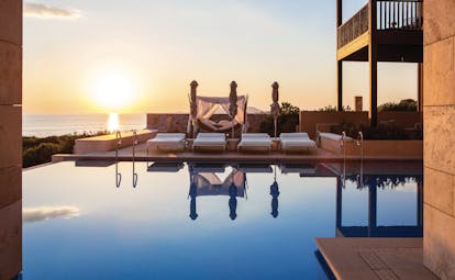 The Romanos Greece outdoor pool sunest with loungers and a hammock