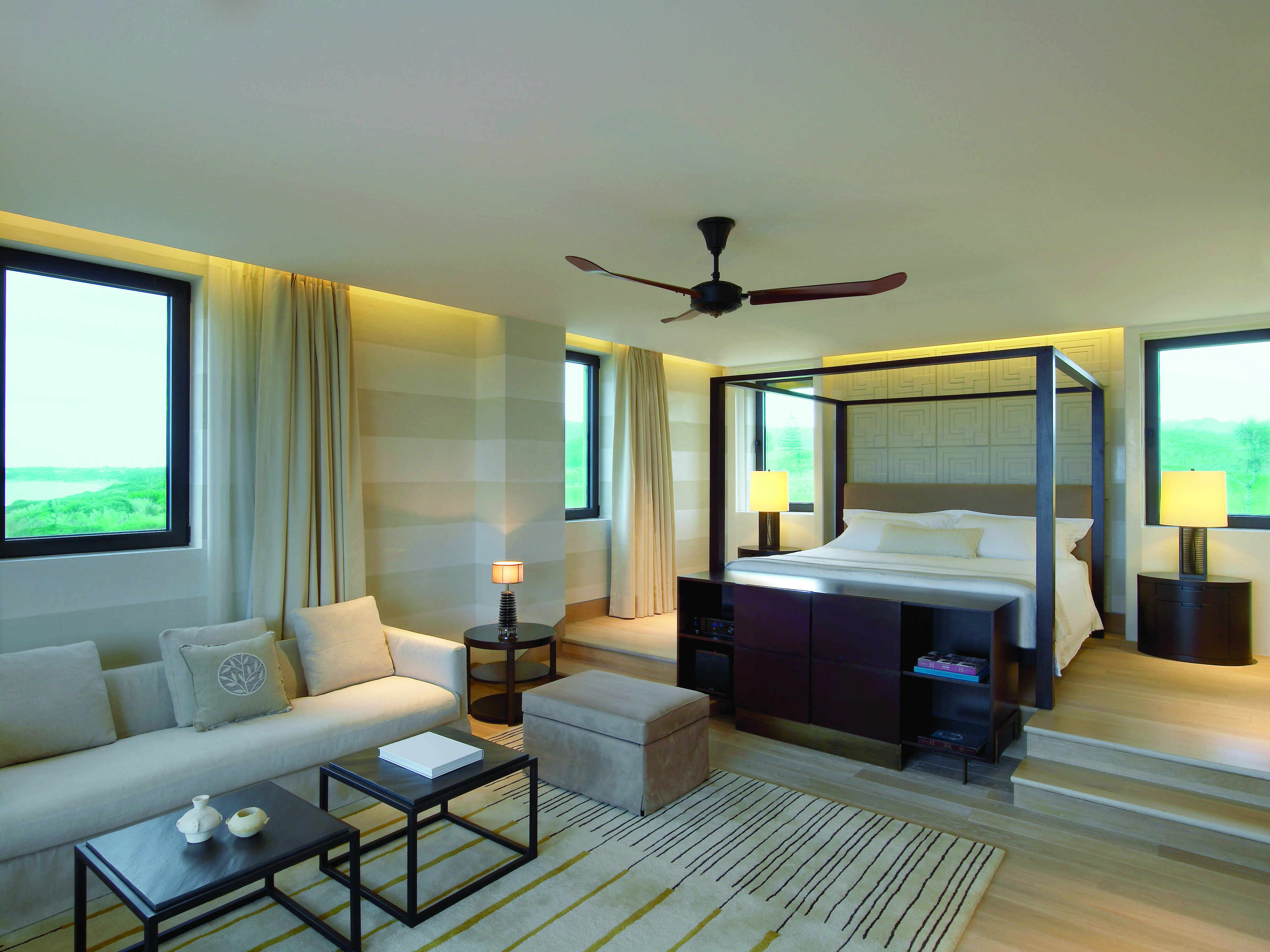 The Romanos Greece suite with sofa and raised sleeping area with large windows