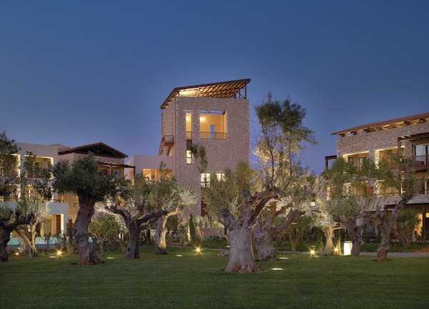 View of the Westin Resort from the outside at dusk, showing it dimly lit and surrounded by palm trees