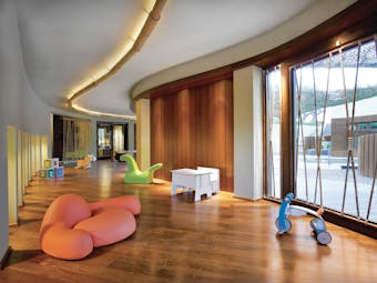 View of the kids club at the Westin Resort with curvy walls, wooden floors and toys scattered around the floor