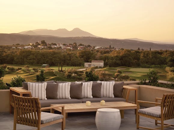 Outdoor lounge area at the Westin Resort with a benched seating area looking over to a mountain range covered by a yellow sunset