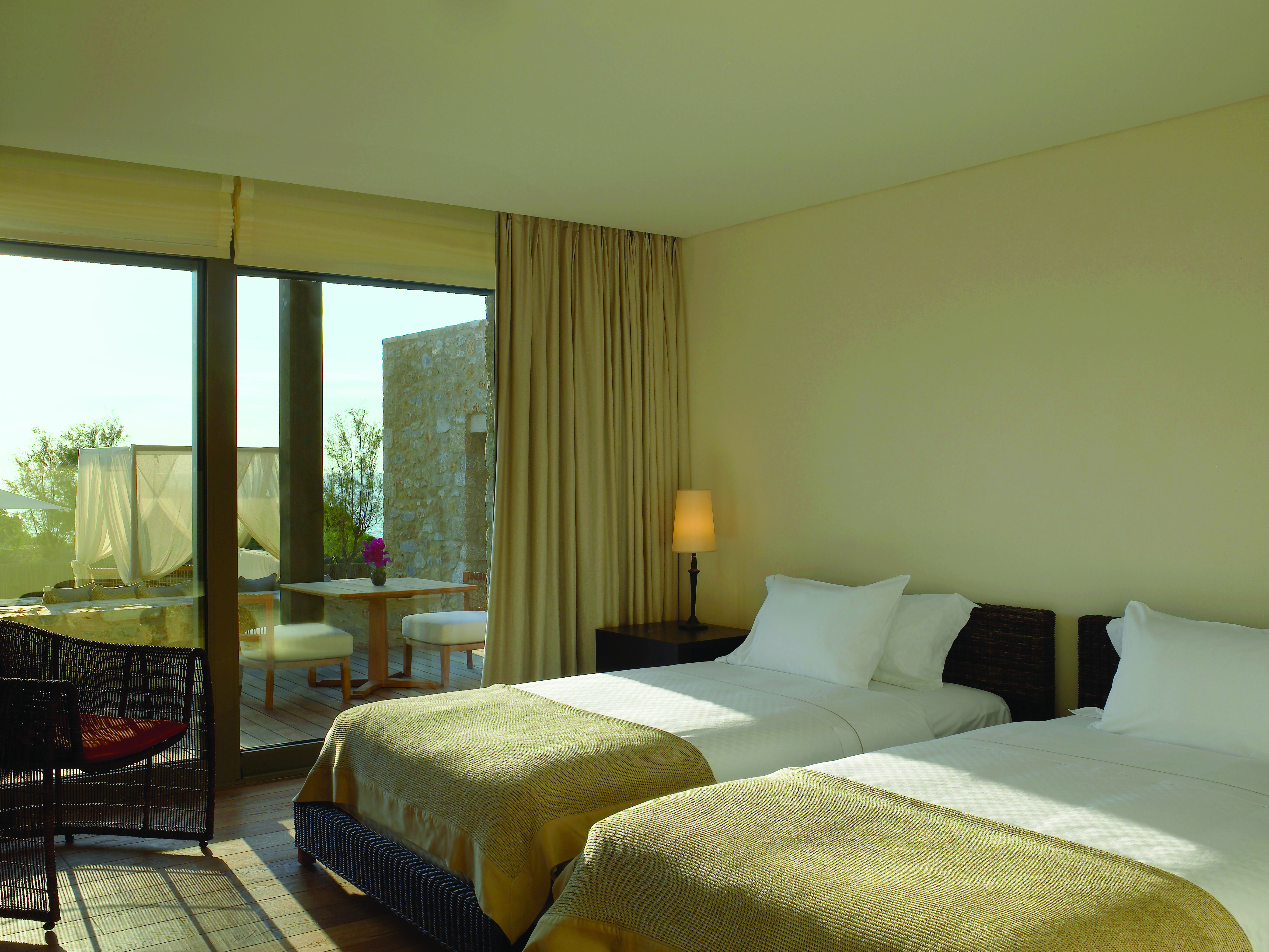 View of a twin room at the Westin Resort with two beds and a large window with doors opening onto a balcony