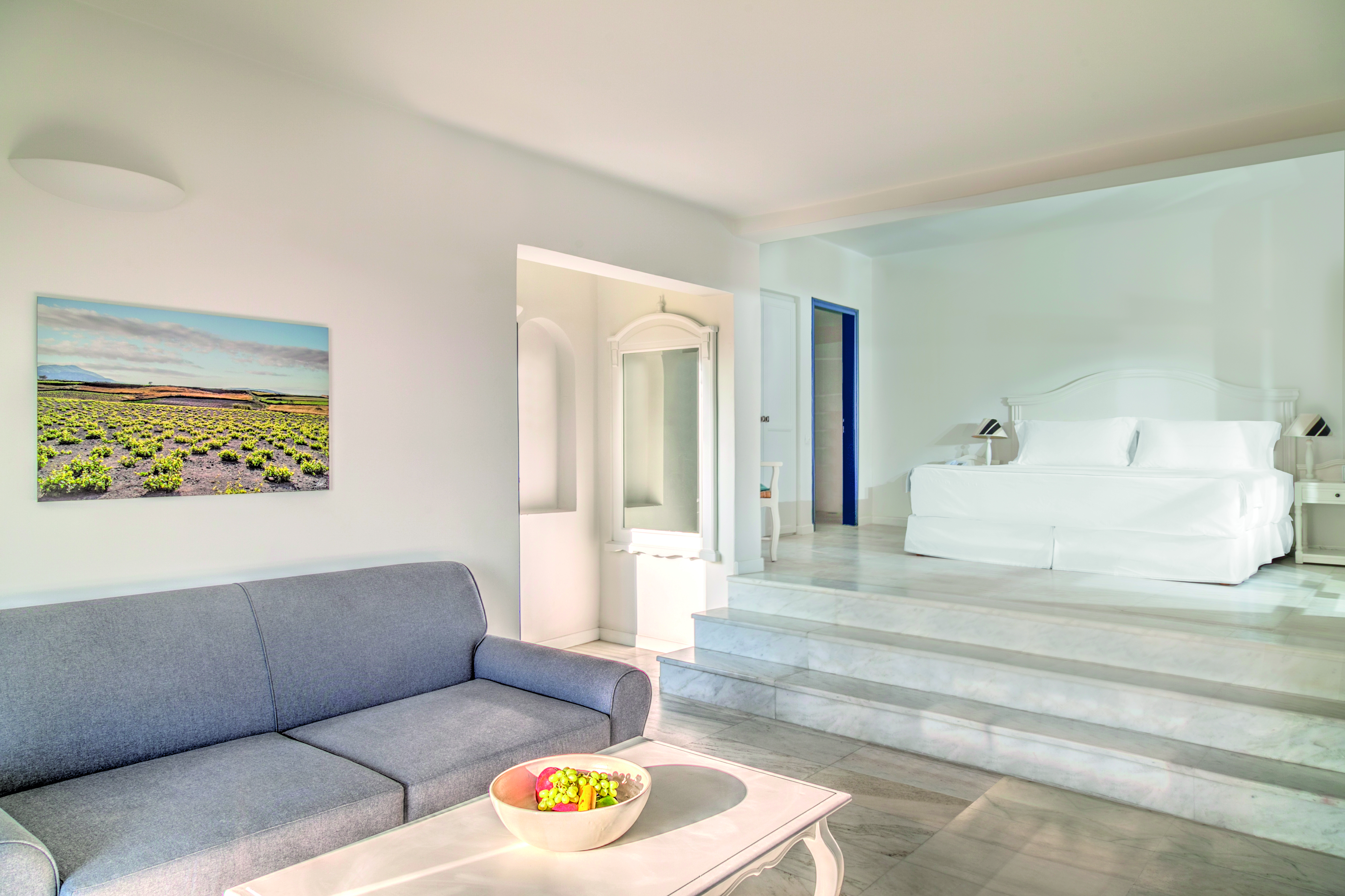 Vedema Resort Greece Aegean suite with lounge area sofa and steps leading to bed