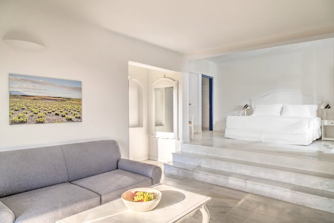 Vedema Resort Greece Aegean suite with lounge area sofa and steps leading to bed
