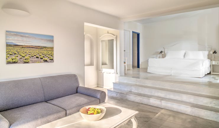 Vedema Resort Greece Aegean suite with lounge area sofa and steps leading to bed