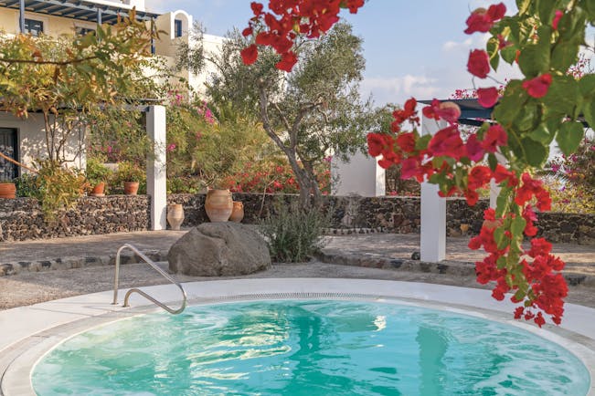 Vedema Resort Greece jacuzzi area with trees and red flowers