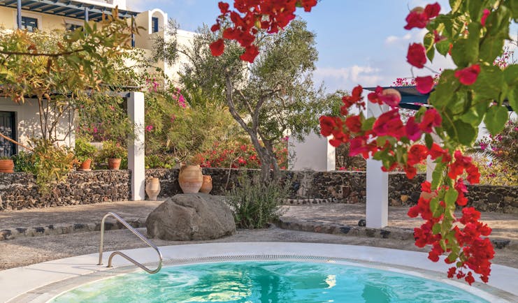 Vedema Resort Greece jacuzzi area with trees and red flowers