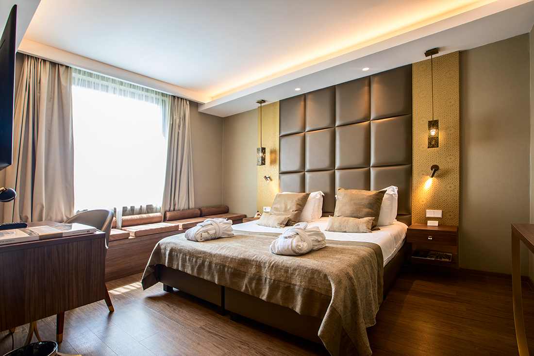 Continental Hotel deluxe room, double bed, desk, armchairs, bright modern decor