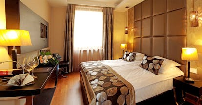 Continental Hotel standard room, double bed, desk, warm modern interiors