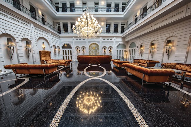 Prestige Hotel Budapest lobby lounge area black marble floor orange sofas and a chandelier