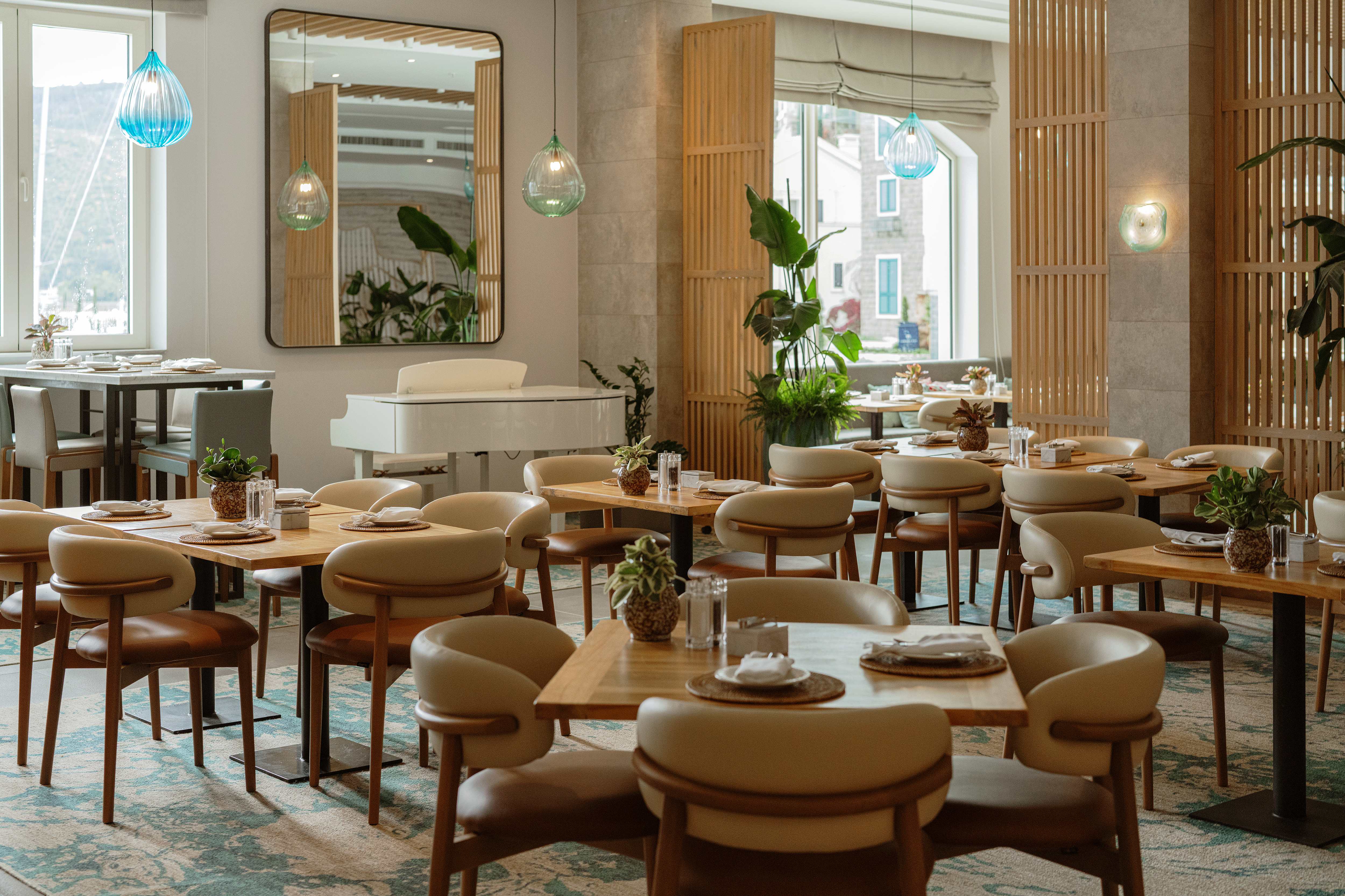Chedi Lustica Bay The Restaurant, with modern neutral furnishings and large marina-facing windows