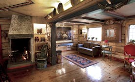 Cosily furnished lounge with wooden panels and rugs at the Elveseter Hotel