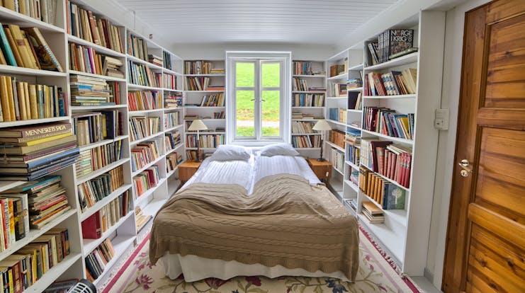 Fjaerland Fjordstove Hotell bedroom in room lined with books on white shelves