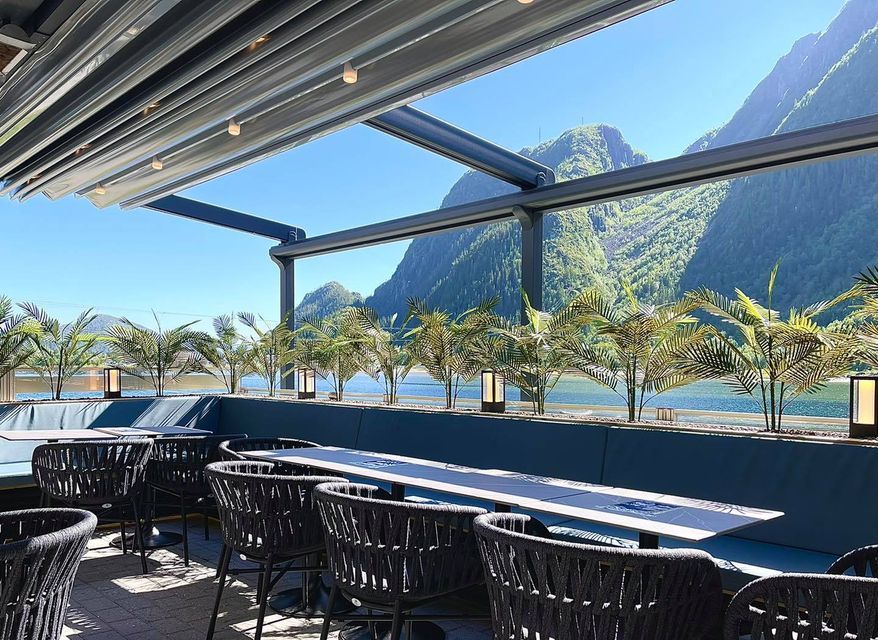 Fru Haugans Hotel Terrace overlooking the river and green mountains beyond