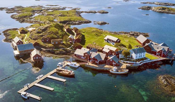 Aerial view of island with jetty, boats and cabins