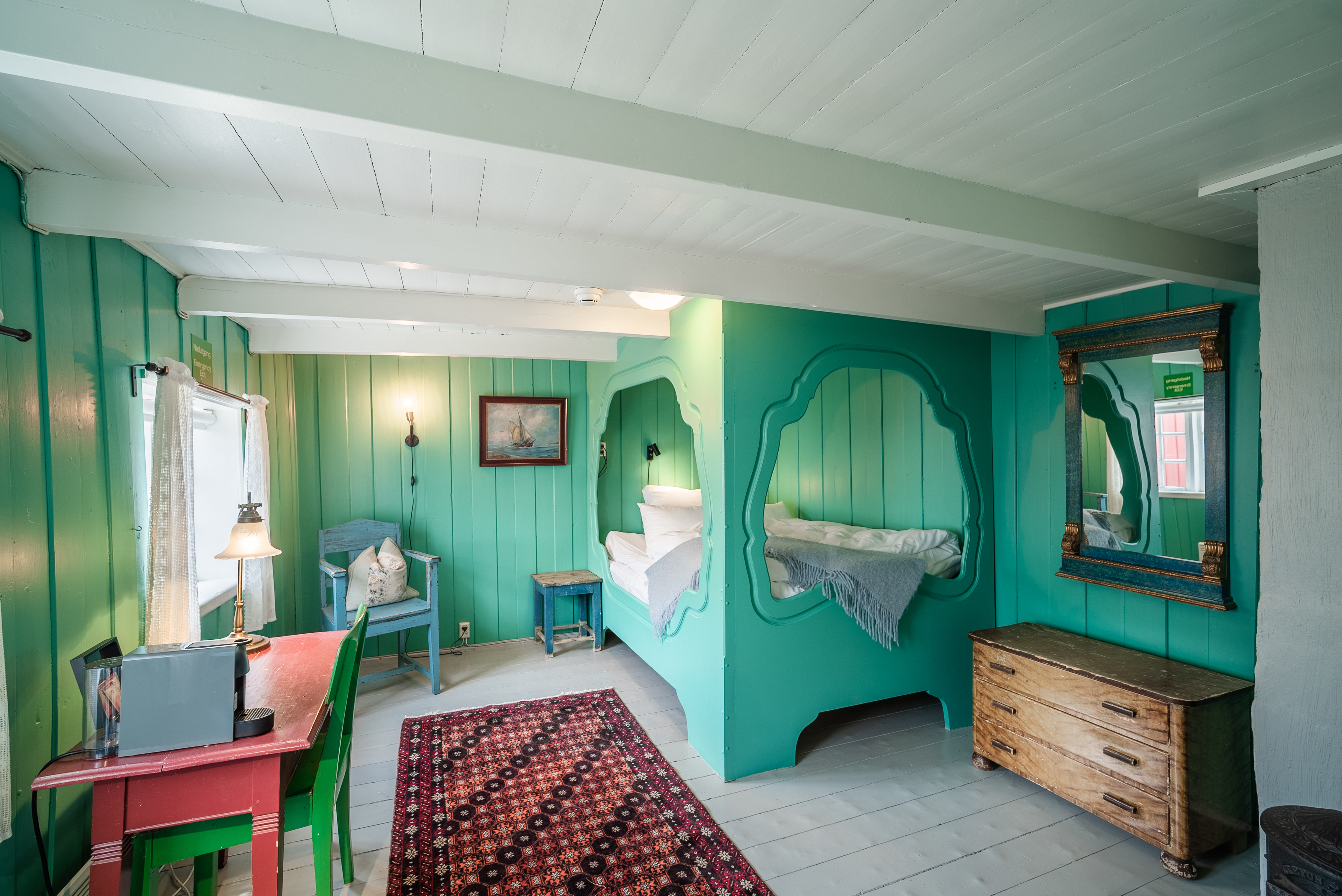 Green bedroom with enclosed bed and green walls.