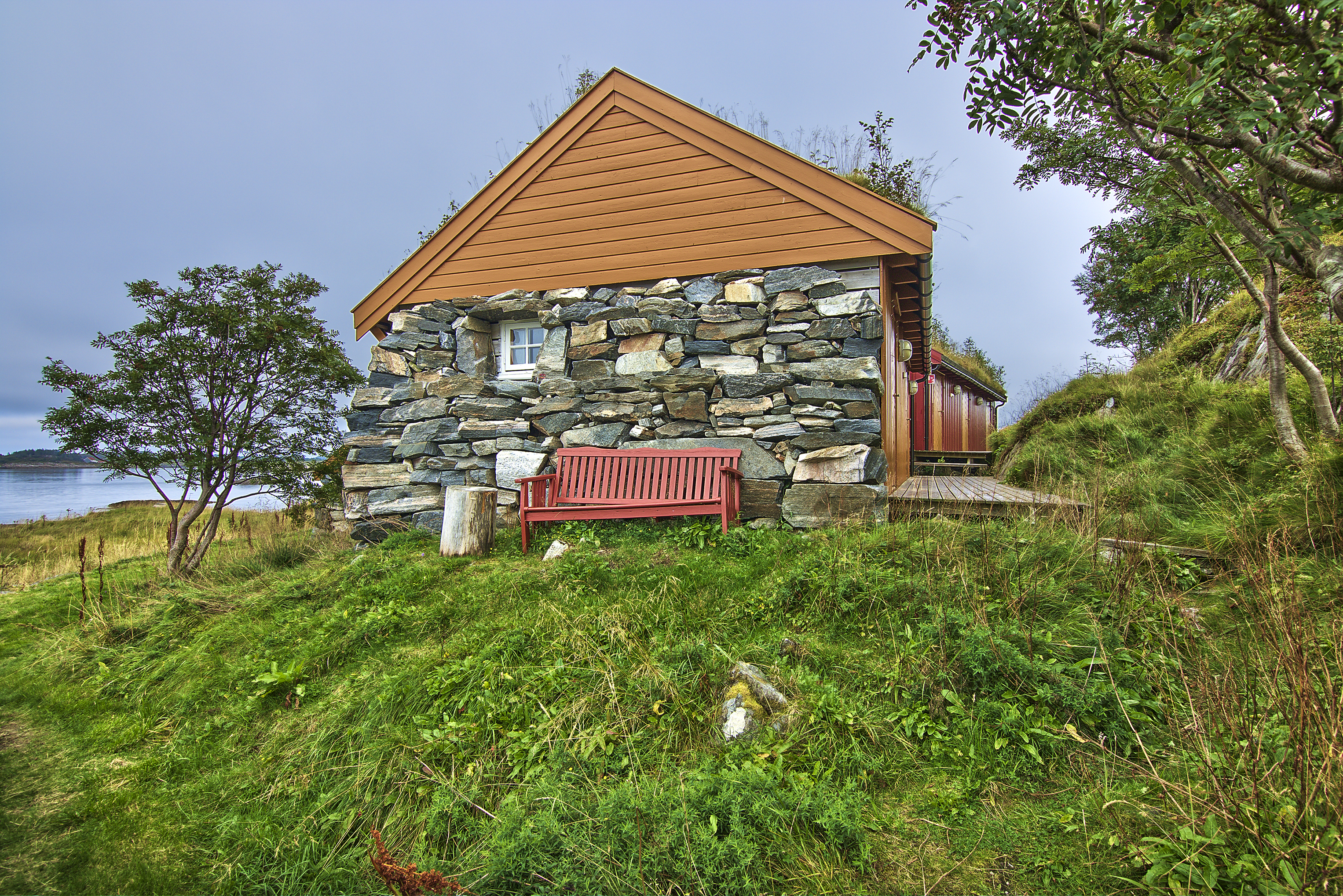 Cabin with red bench and trees