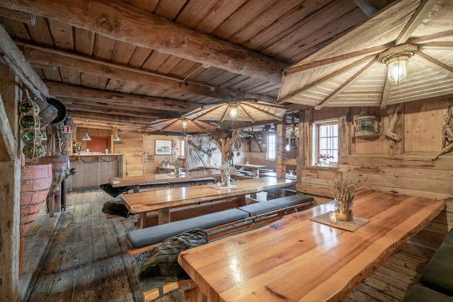 Inside of wooden cabin with long wooden dining tables