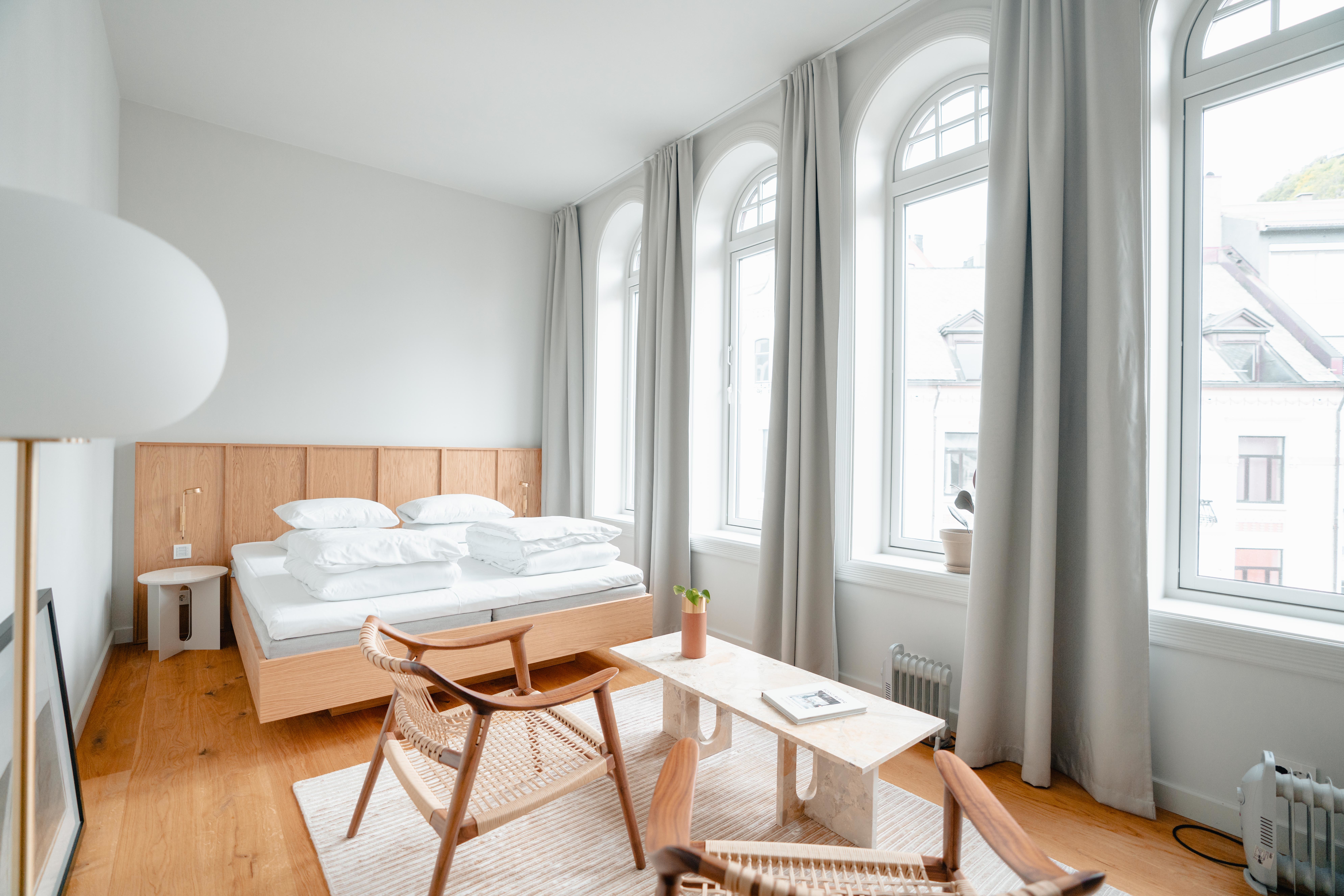 Hotel 1904 Deluxe room with large arched windows and white and light wood furnishings