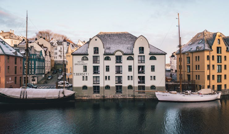 Hotel Brosundet Alesund exterior of white building with yellow building next door on waterfront