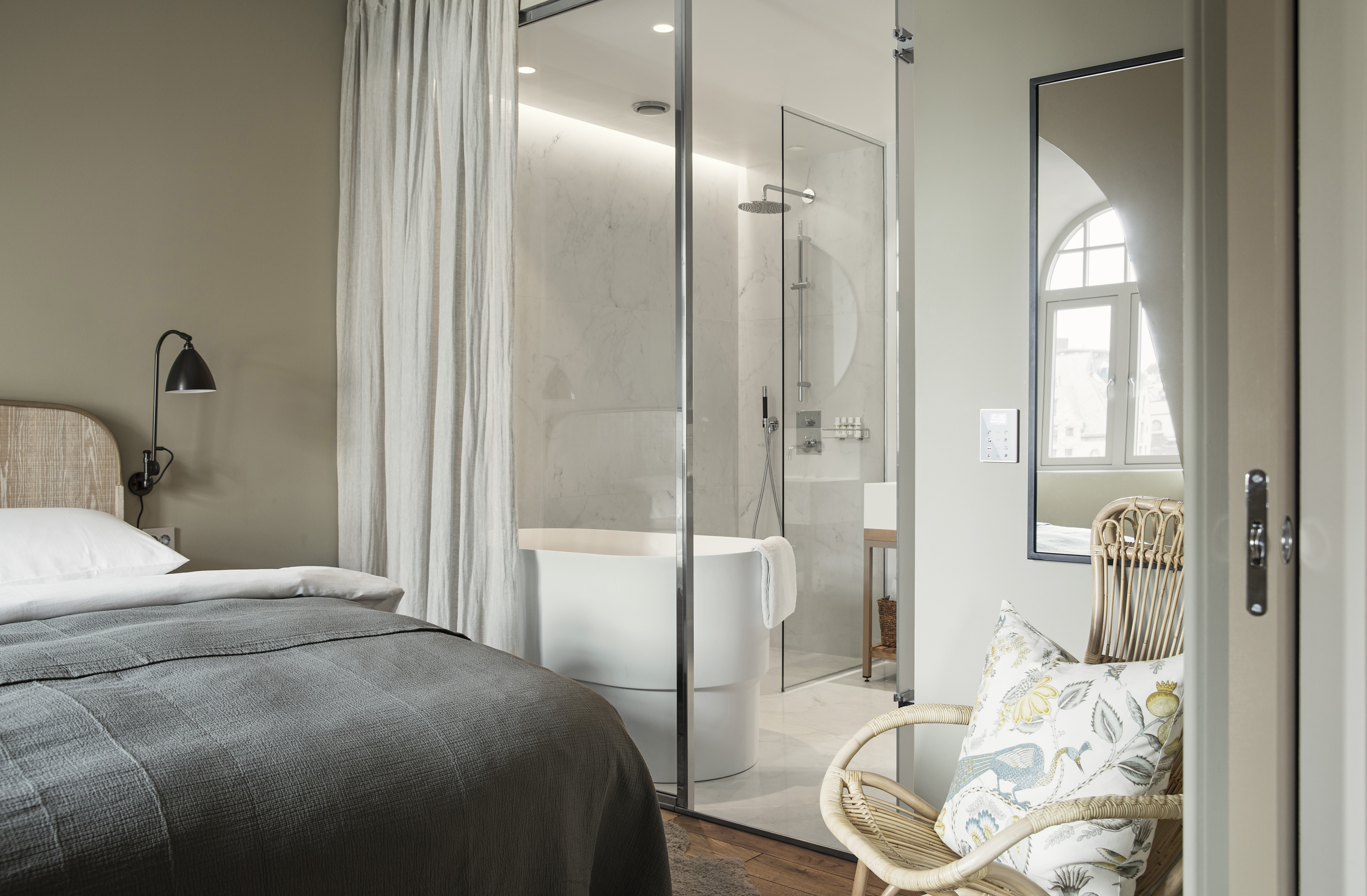 Hotel Brosundet Alesund bedroom with grey covers and glass bathroom window