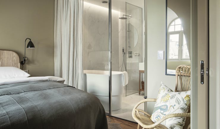 Hotel Brosundet Alesund bedroom with grey covers and glass bathroom window