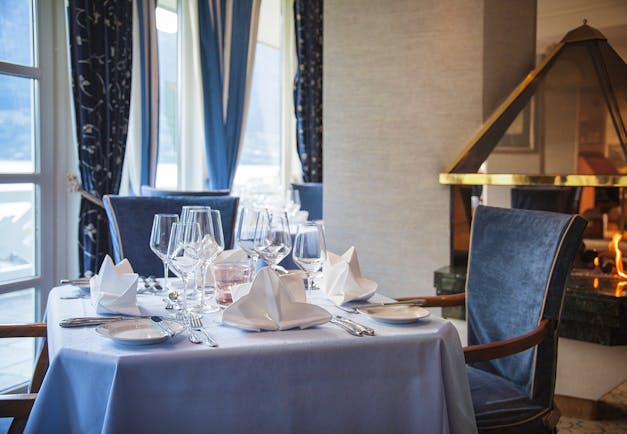 Hotel Ullensvang Norway table with blue tablecloth and open fire behind