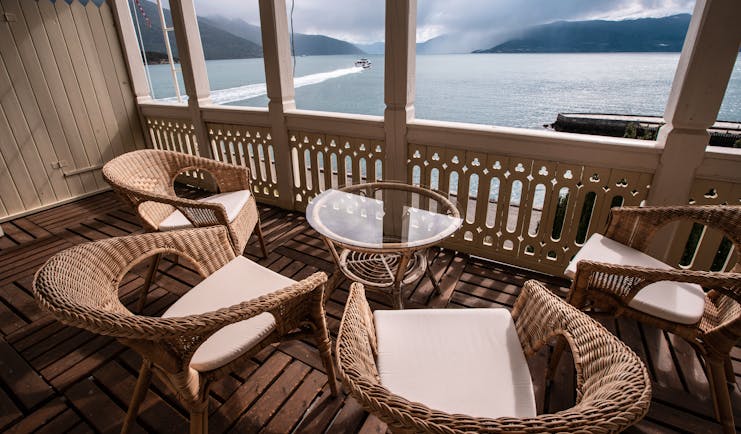 Four wicker seats on balcony overlooking fjord at Kviknes Hotel