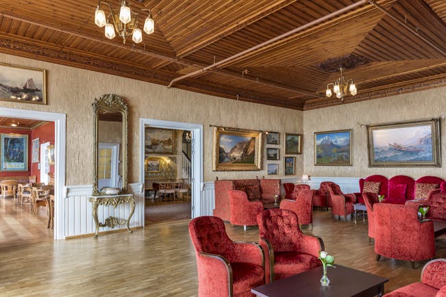 Red armchairs in lounge with wooden floor Kviknes