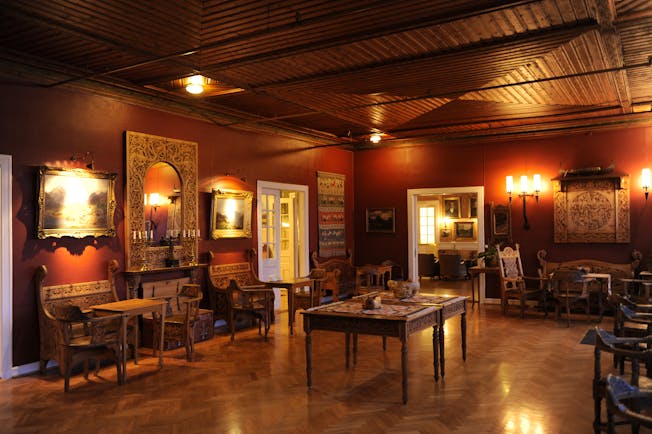 Dark wooden room with lights on walls and antique rustic furniture at Kviknes hotel