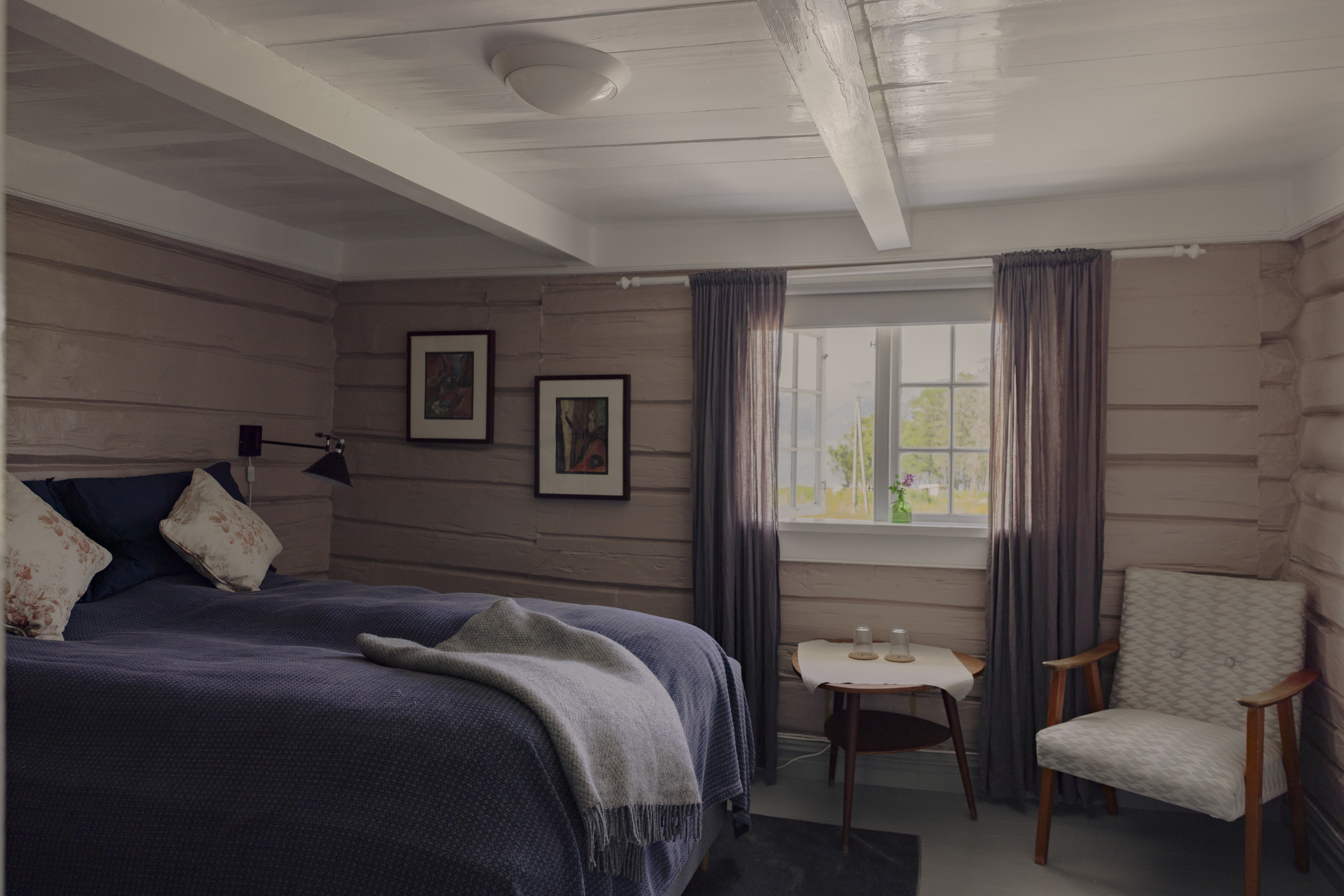 Kvitnes Gard guestroom with neutral palette, blue bedding, low ceilings and cosy feel