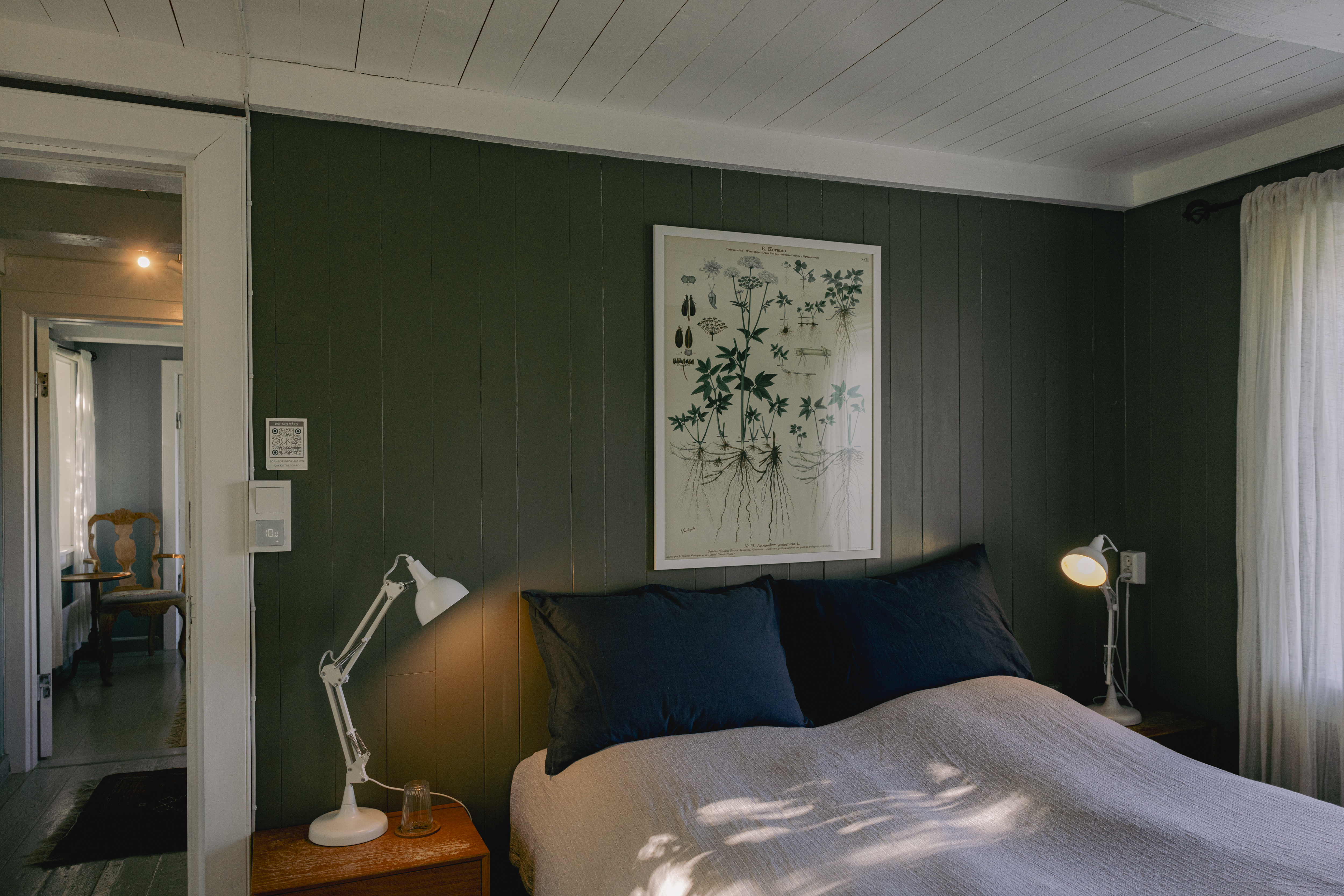 Kvitnes Gard guestroom with light, natural colour palette, white bed linen, sage walls, and white ceiling