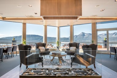 chairs and tables in open restaurant with views of mountains
